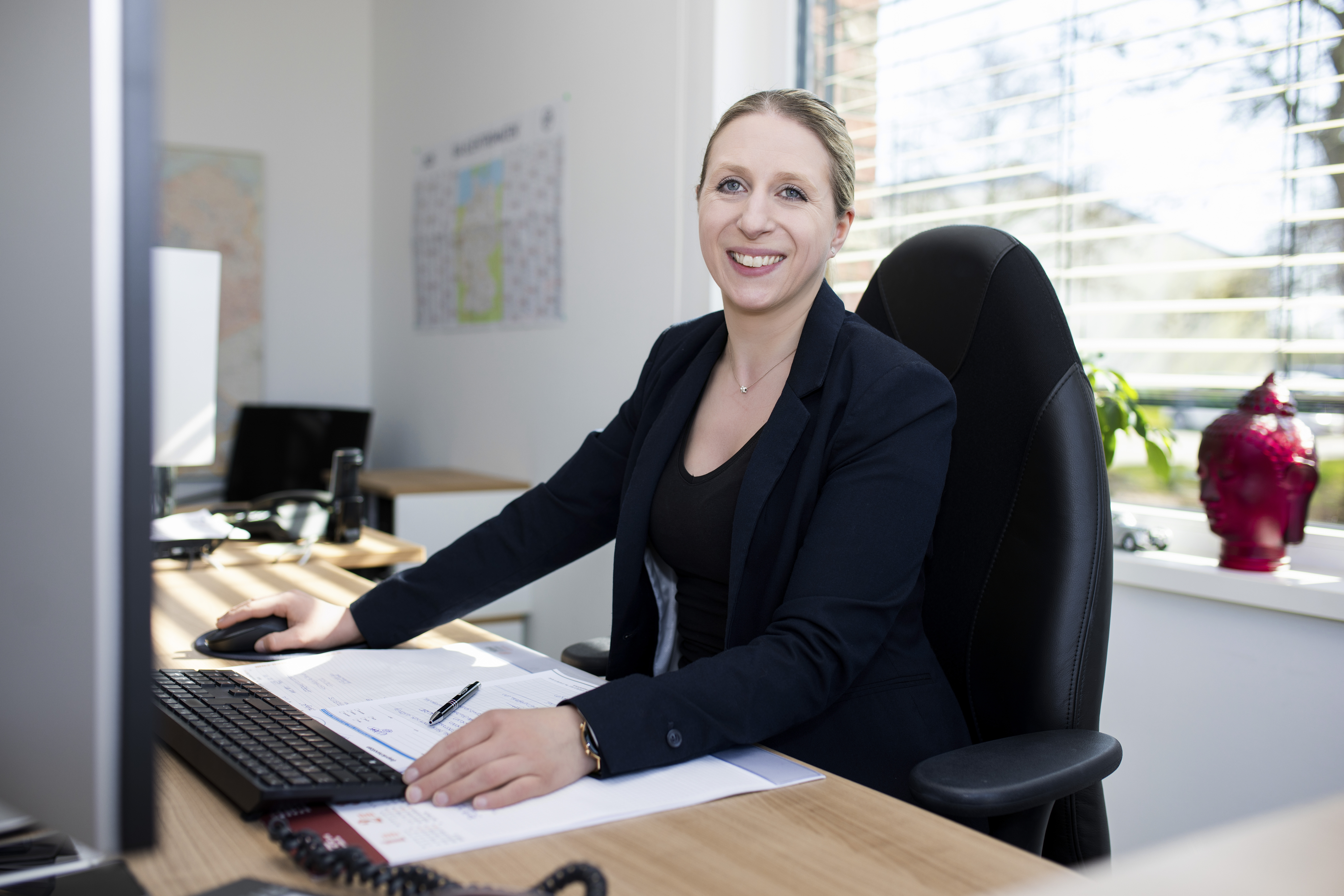 Monteur steht vor dem Firmengebäude neben seinem Dienstfahrzeug